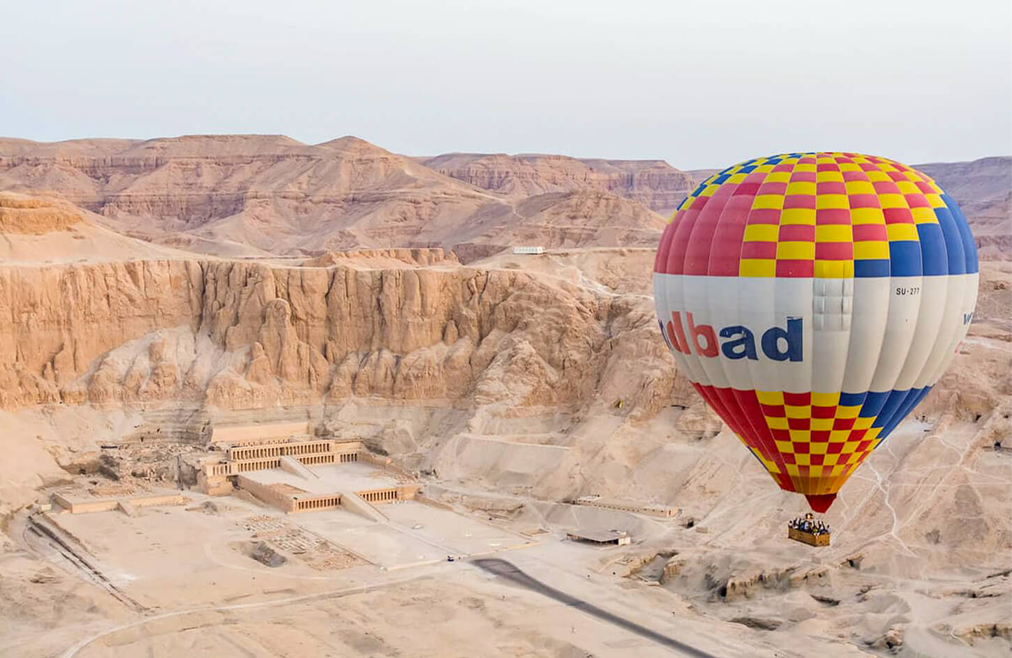 A hot-air balloon over Hatshepsut Temple at sunrise
