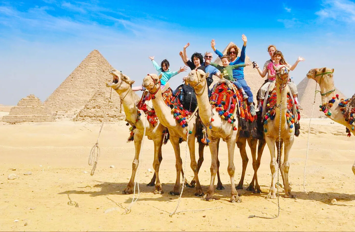 Family riding camels at the Giza Pyramids