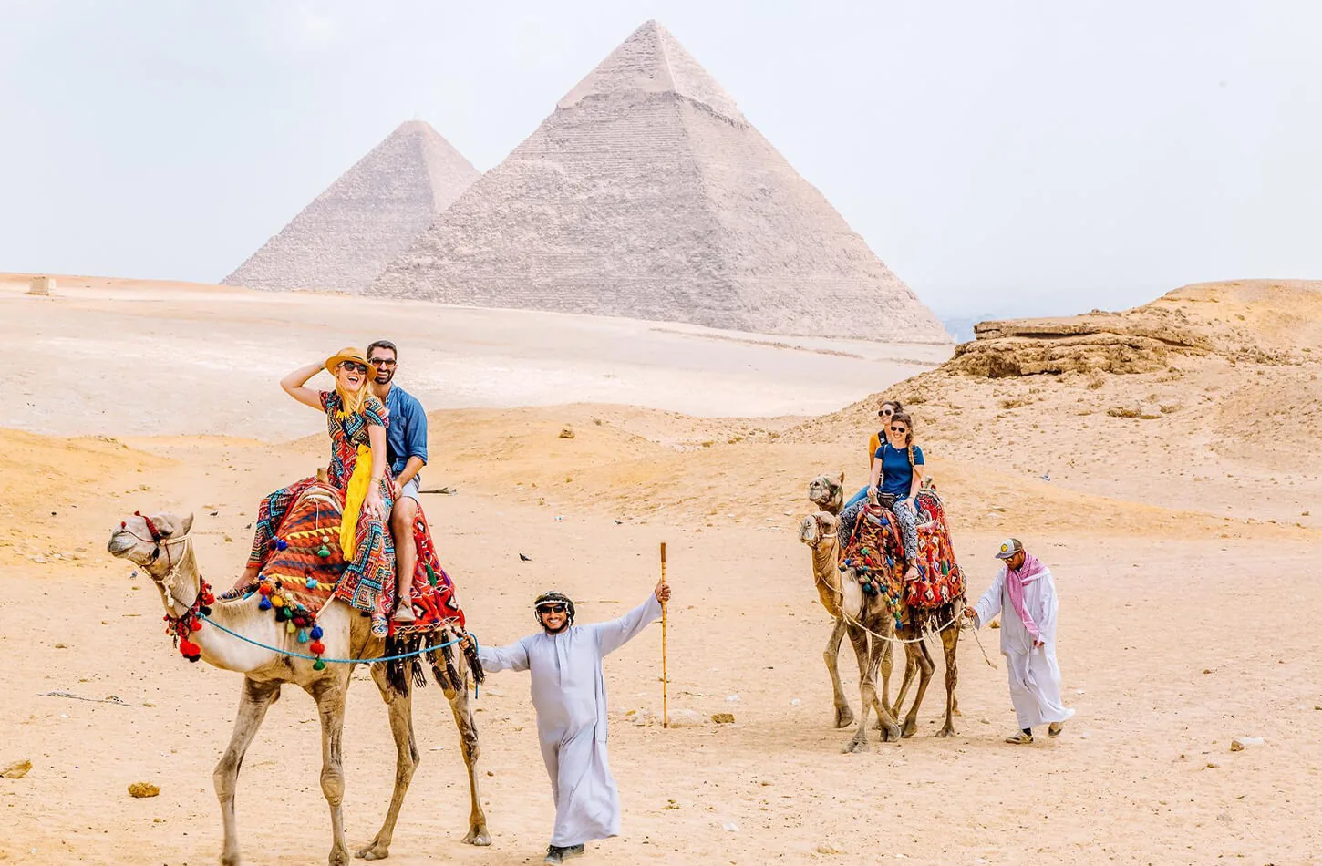 Tourists riding camels near the Giza Pyramids